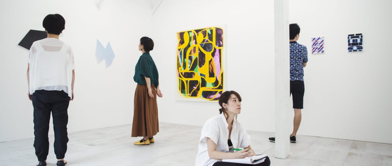 Four people in art gallery looking at modern painting